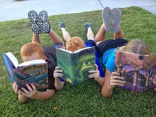SleepTalk schoolchildren reading books outside on the lawn